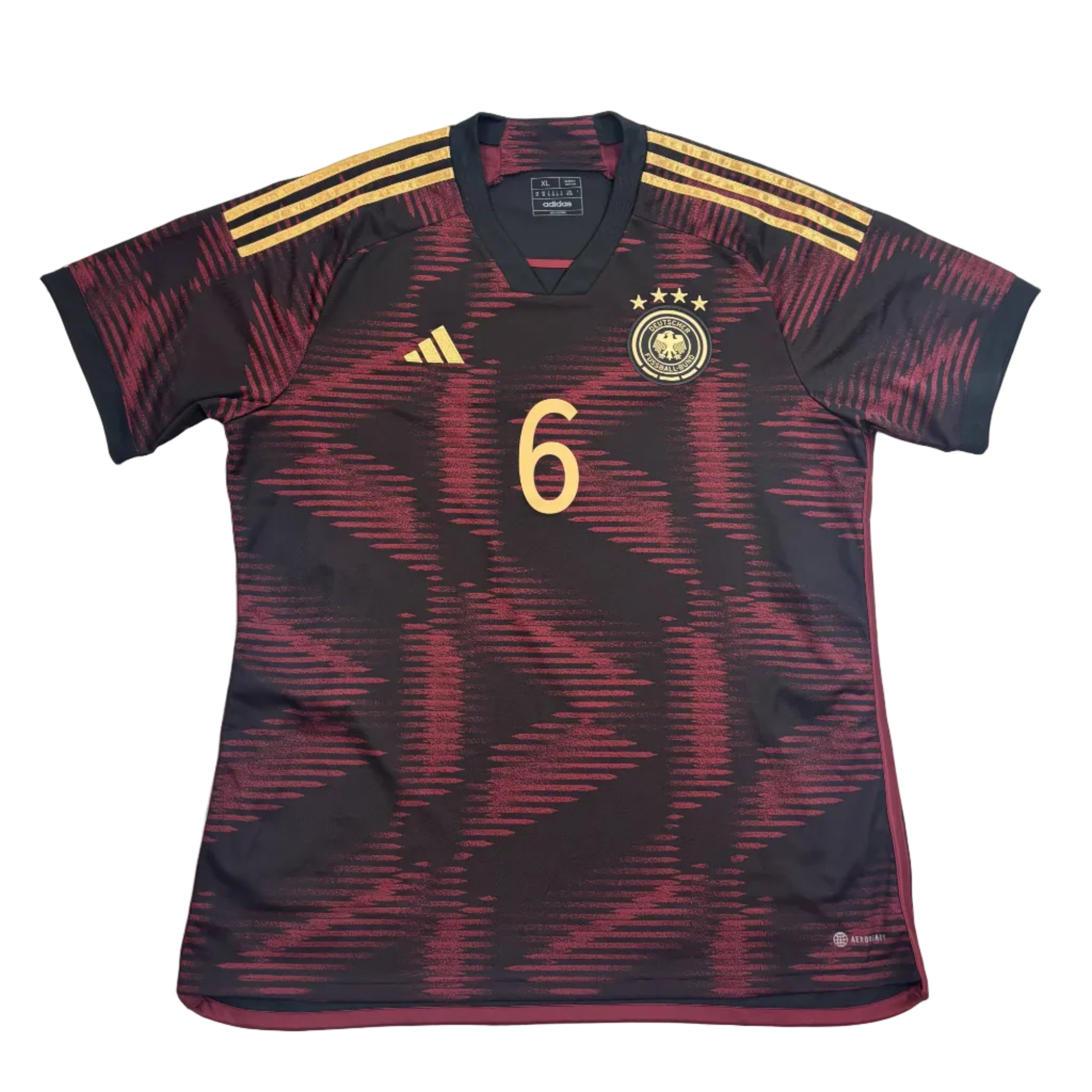 Black and red sports jersey with gold accents on a white surface, surrounded by packaging.