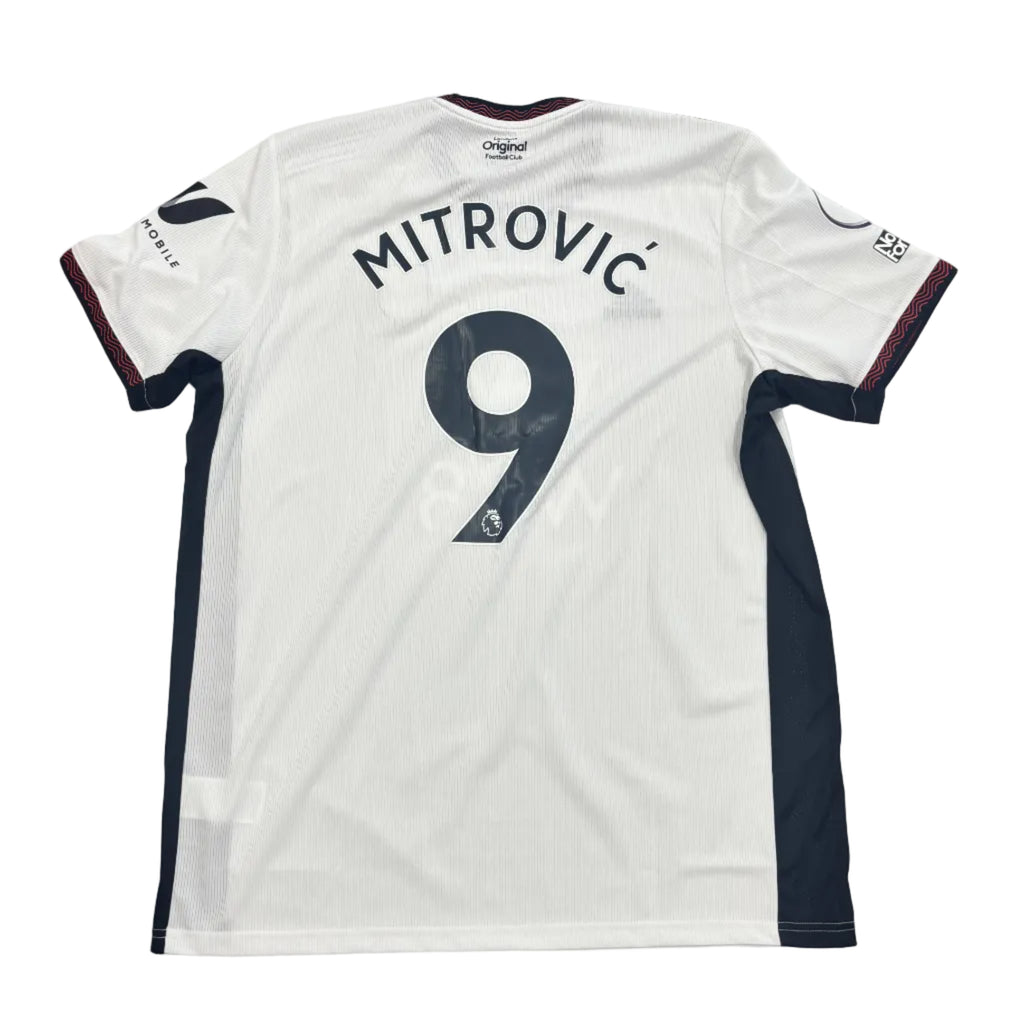 White sports jersey with 'Mitrovic' and number '9' on a round white table.