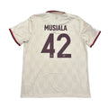 Beige sports jersey with 'Musiala' and number '42' on a round surface.