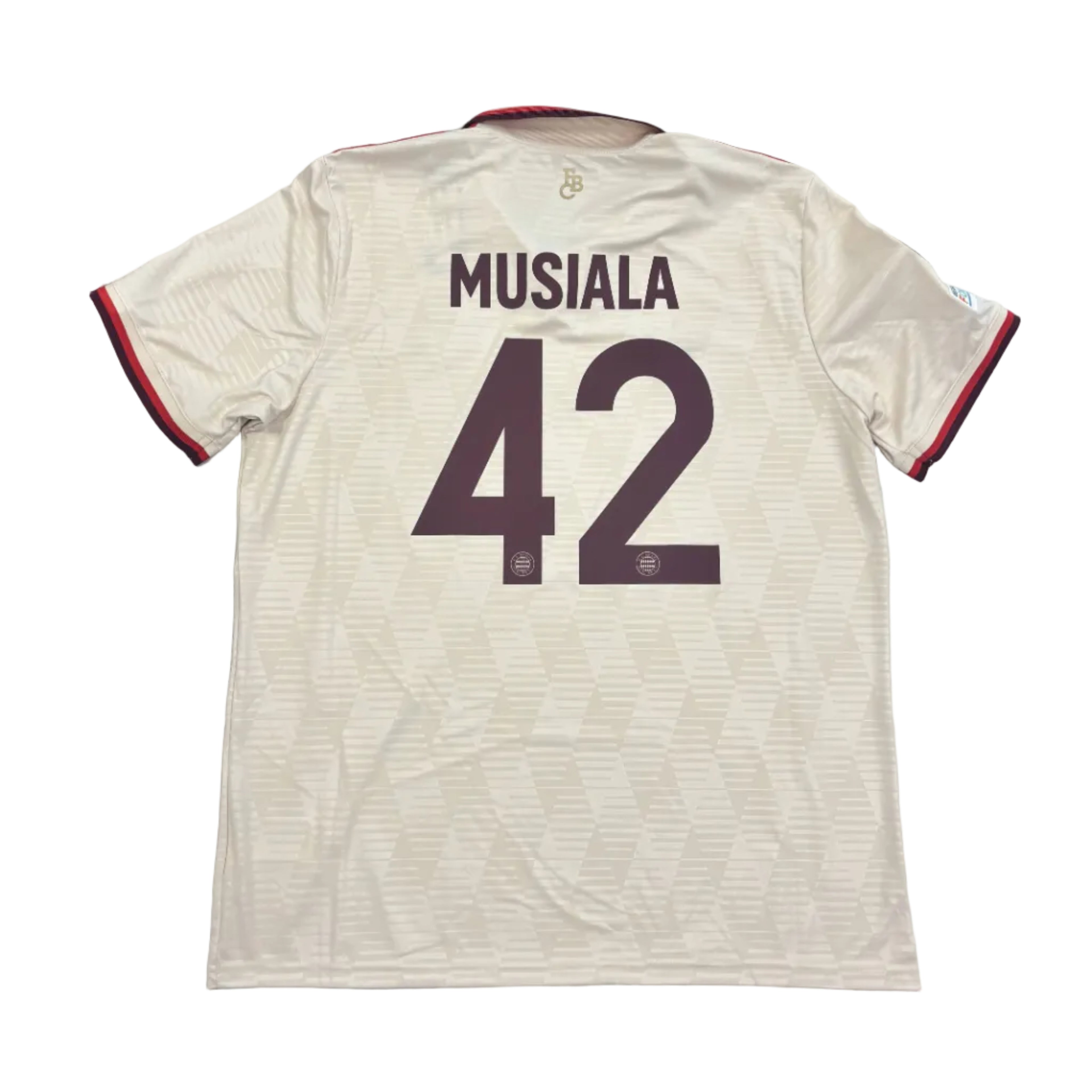 Beige sports jersey with 'Musiala' and number '42' on a round surface.