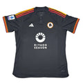 Black sports jersey with orange and red accents on a white surface